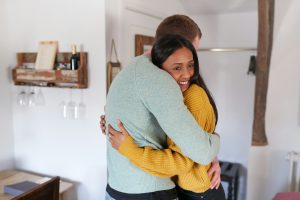 Couple Spending Romantic Weekend Away Hugging In Hotel Room